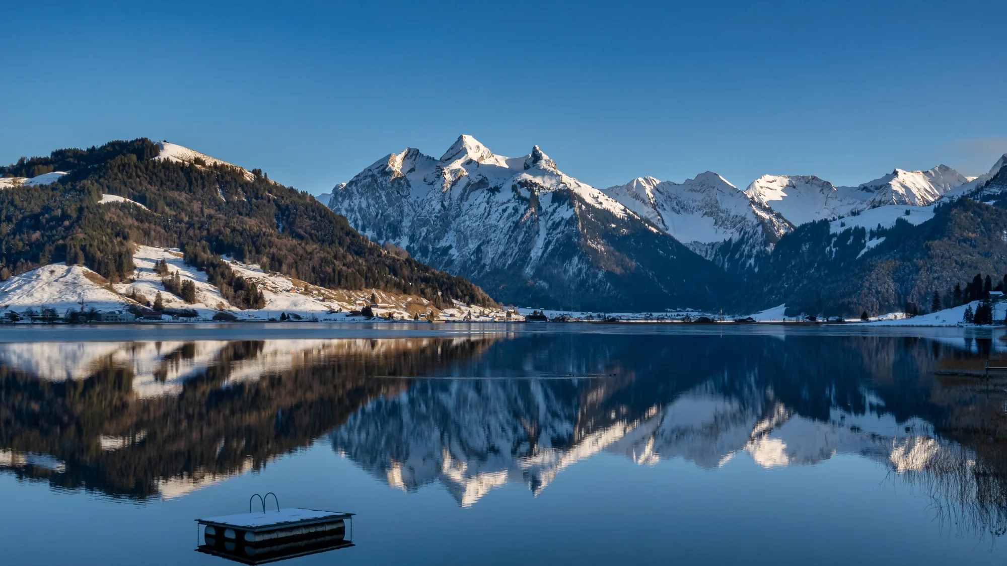 Der Sihlsee bei Einsiedeln mit verschneitem Ufer und Bergkulisse