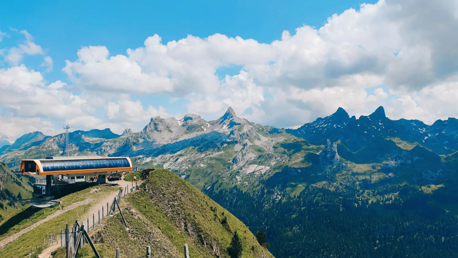 Stazione a monte di una seggiovia sulla cresta, sullo sfondo cime rocciose frastagliate