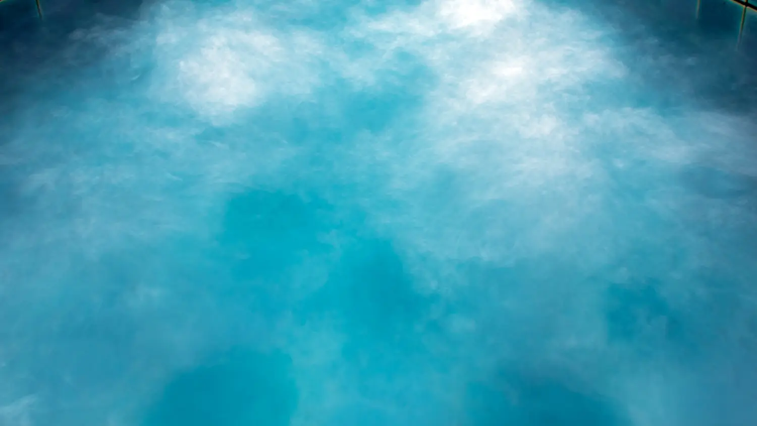 Eau turquoise d'un bain minéral d'où monte la vapeur